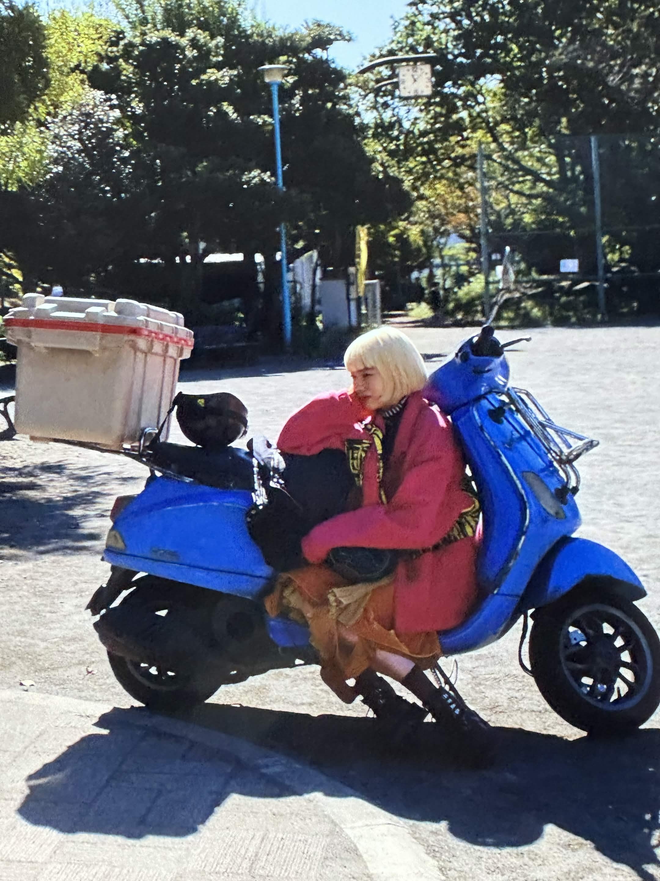 Perfect Days — pink jacket / blue scooter disruption